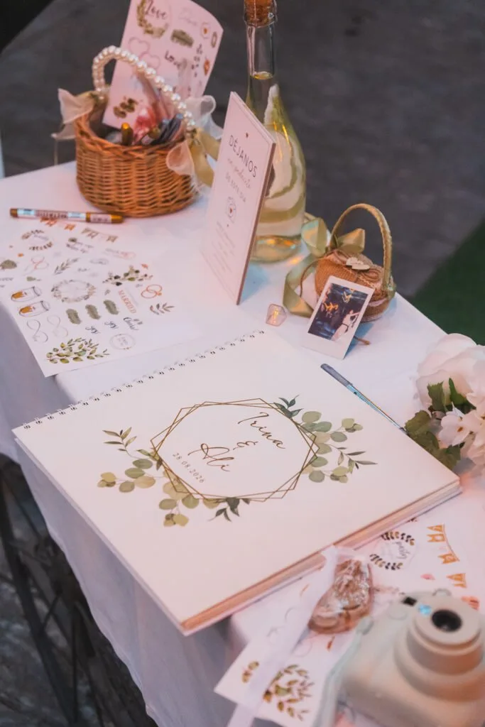 Mesa de detalles con libro de firmas, cámara instantánea y flores