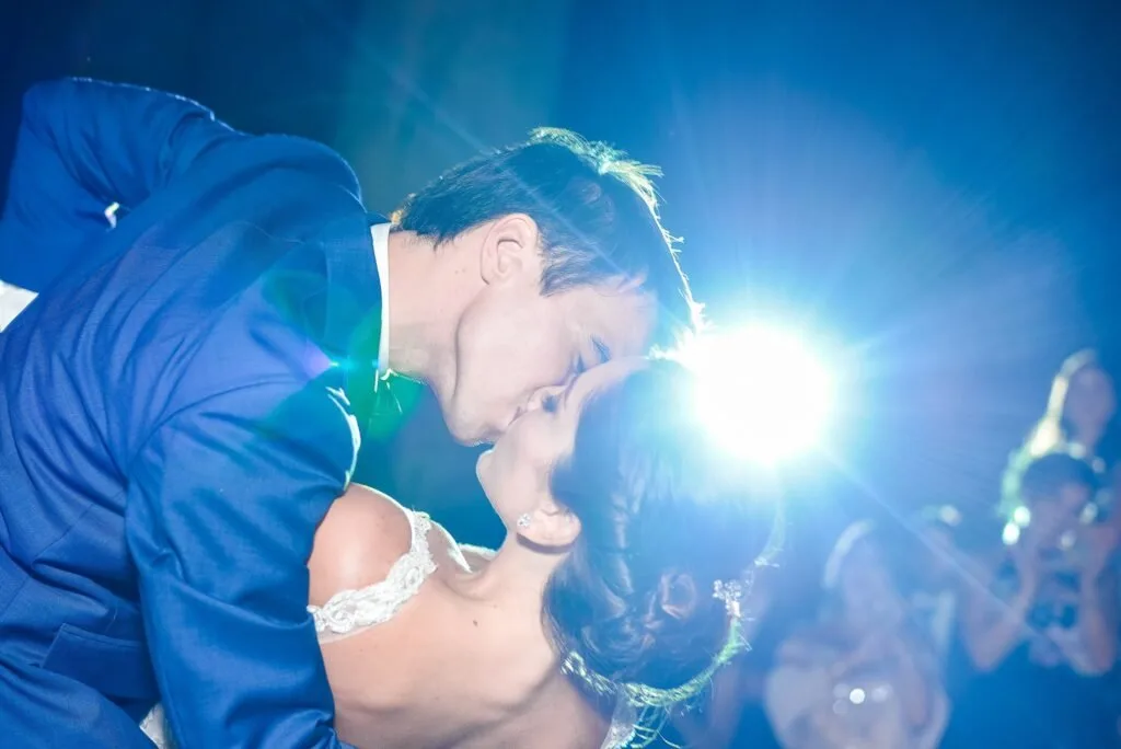 Couple kissing under blue light on the dance floor