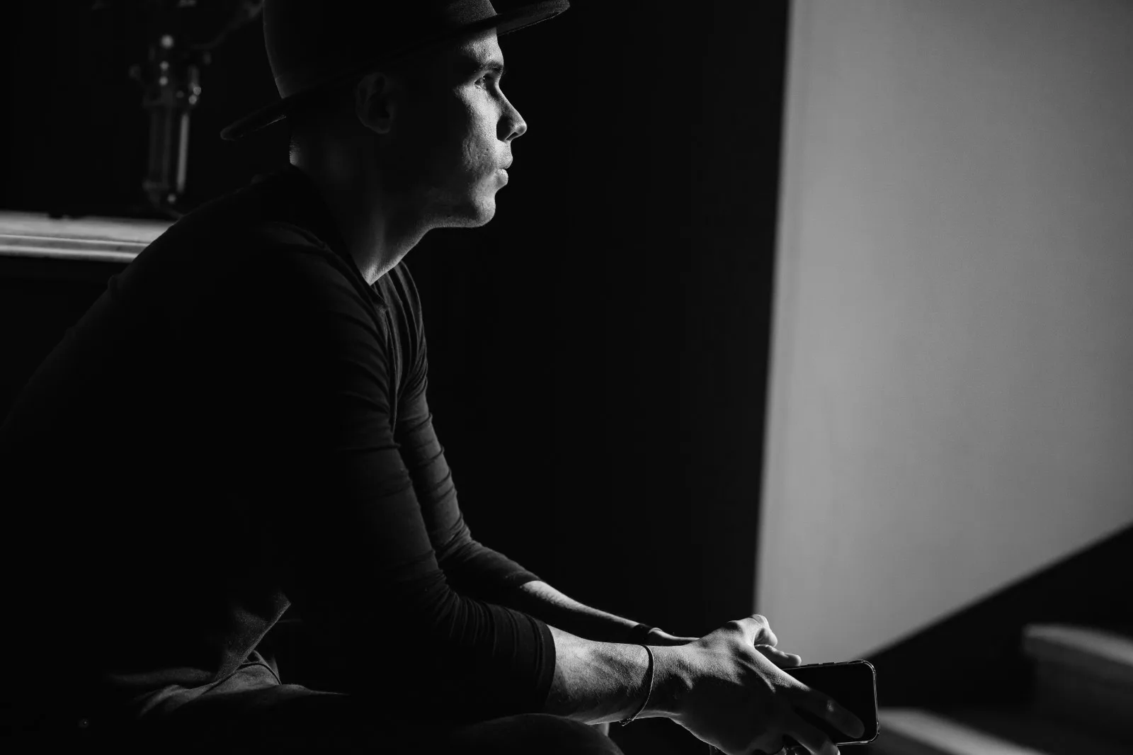 The photographer in black and white, seated against the light, hat on