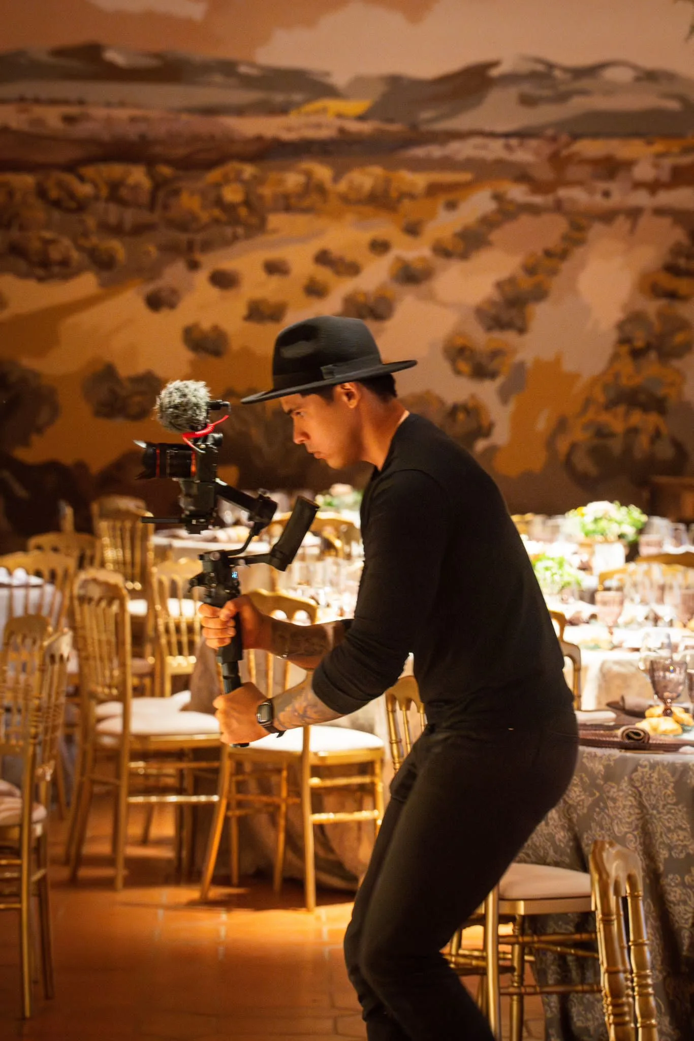 El videógrafo colocando la cámara entre las mesas de un banquete