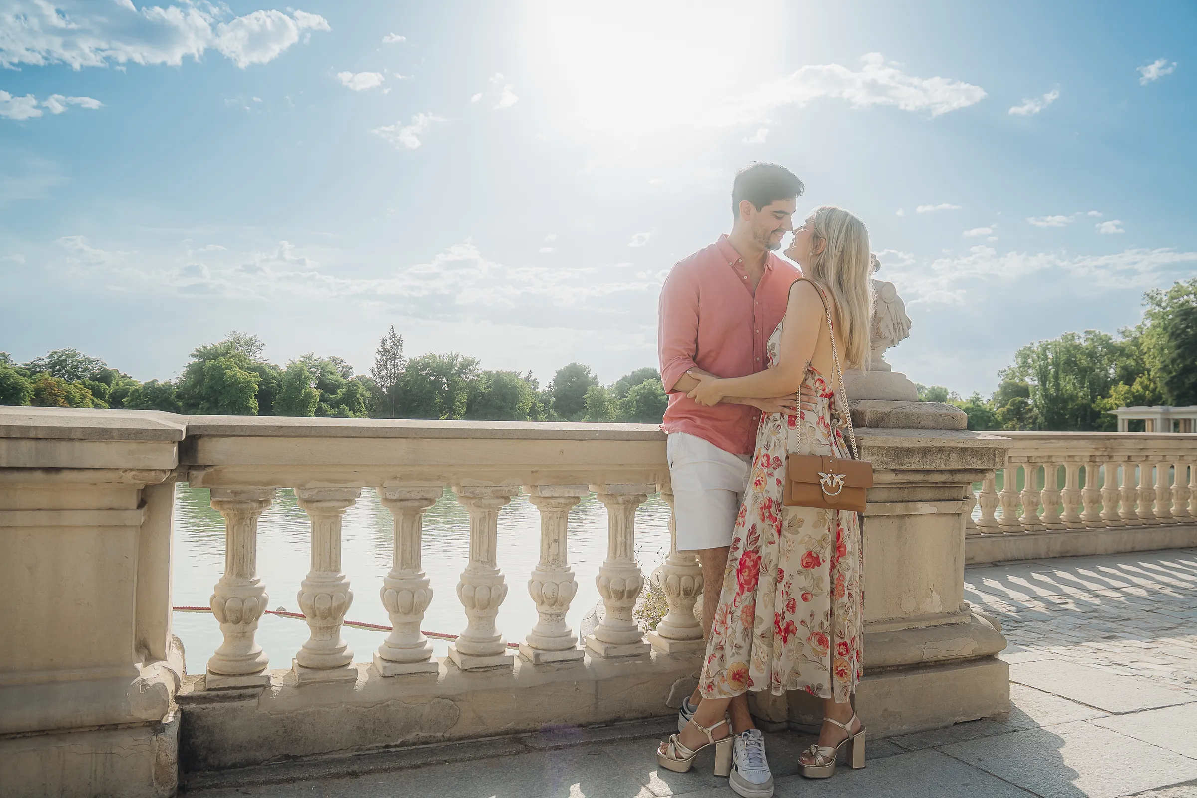 A couple backlit on a stone balustrade, the sun right behind them