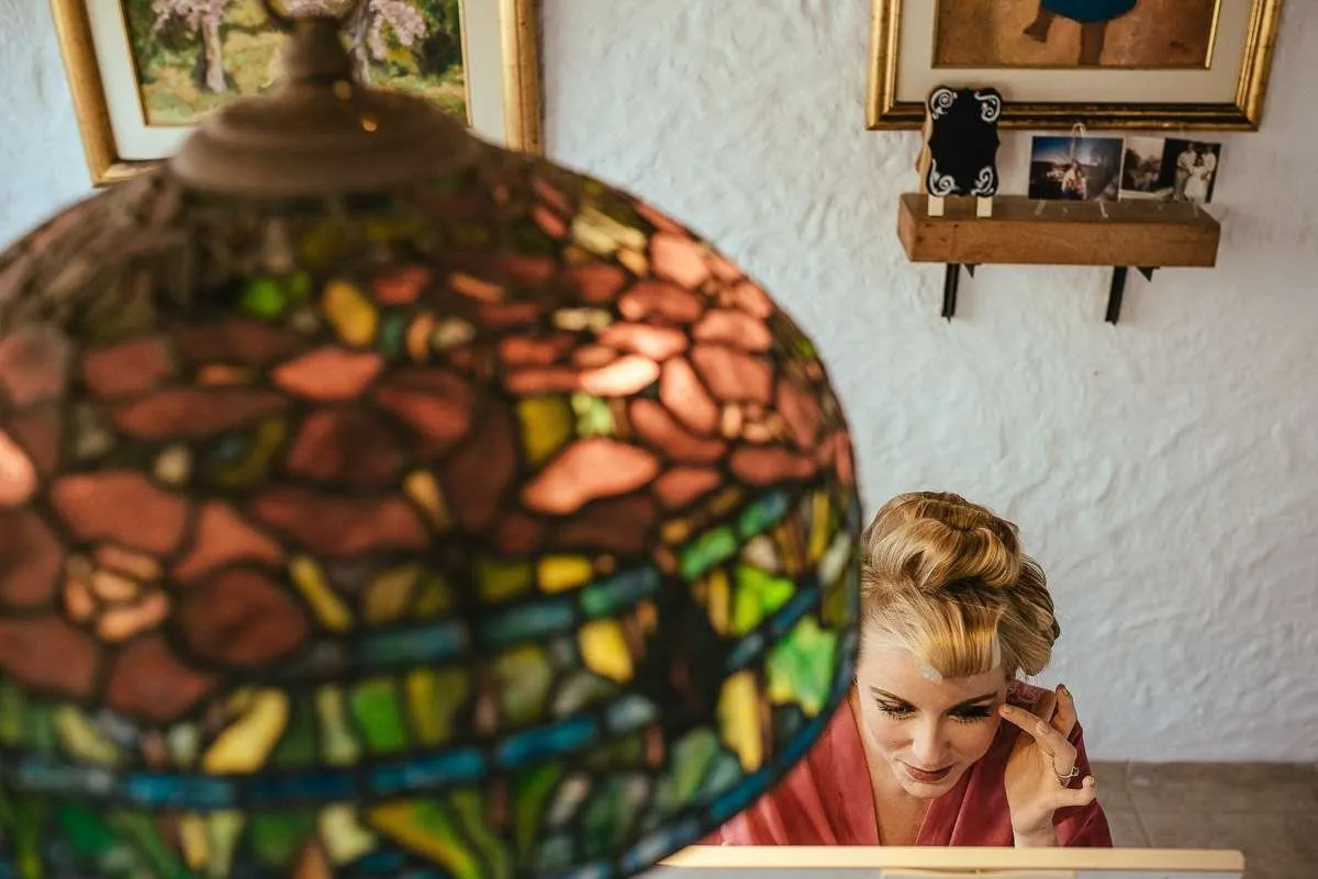 Stained-glass lamp with a seated woman in the background