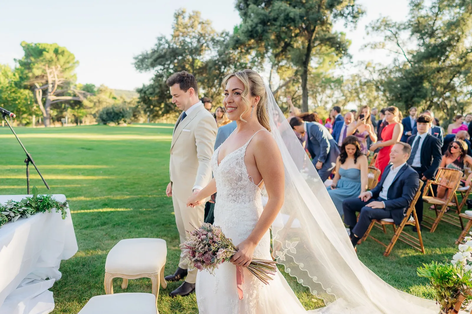 The couple look at each other during the ceremony, guests seated behind