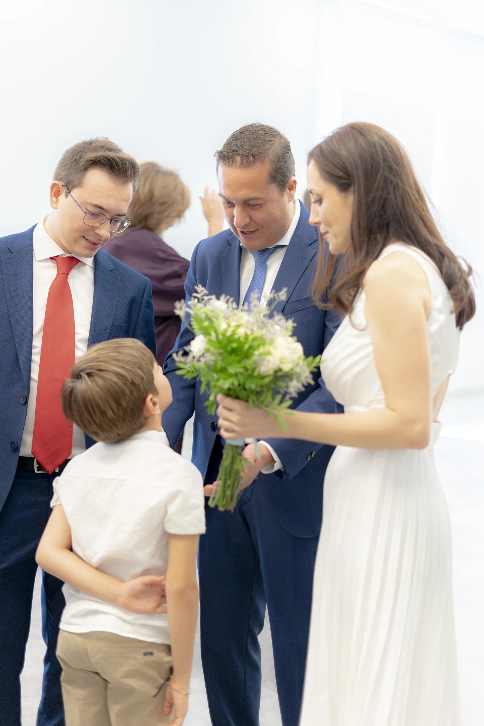 Novia con ramo y un niño junto a los invitados