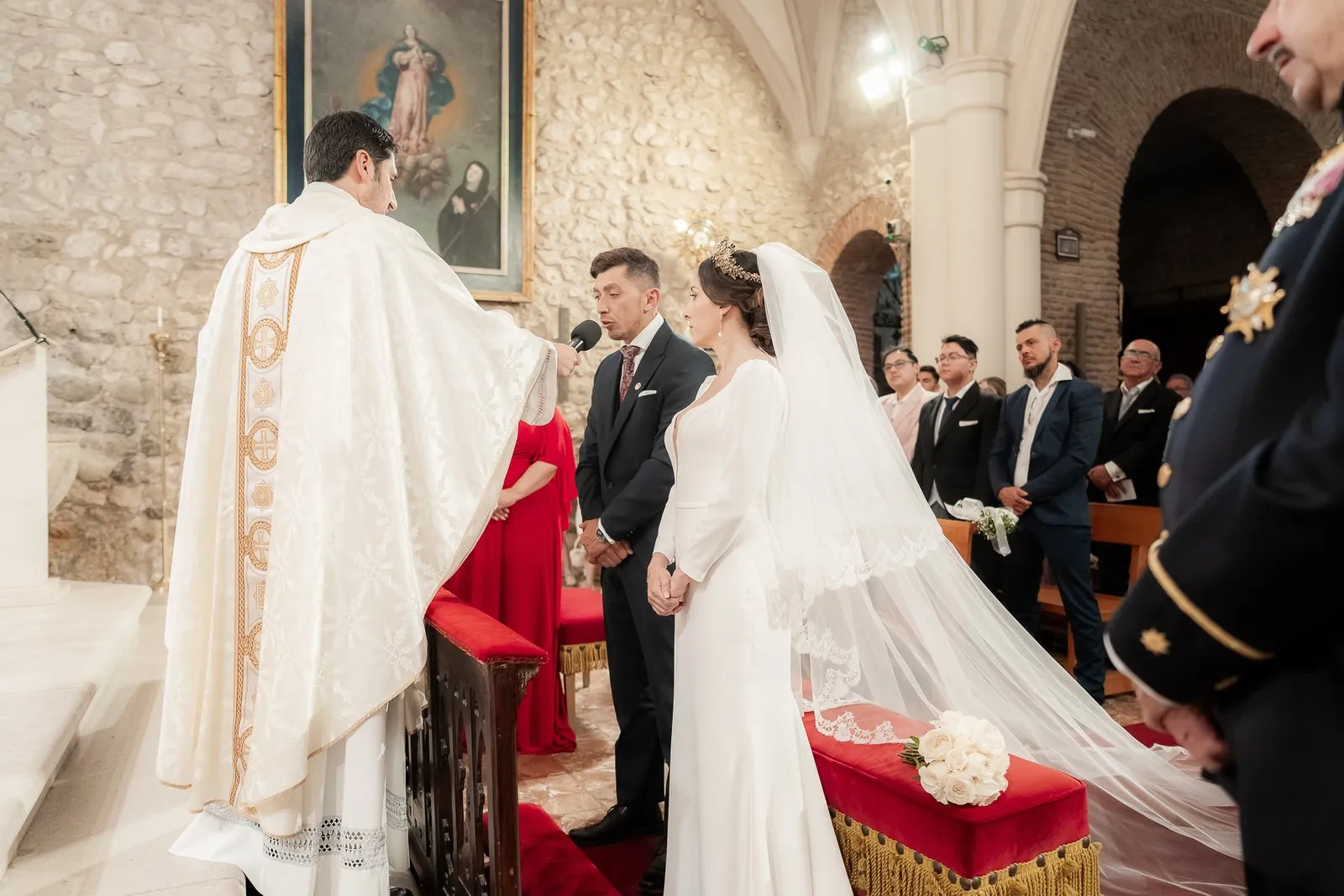 A priest stands before the couple in a religious ceremony inside a church