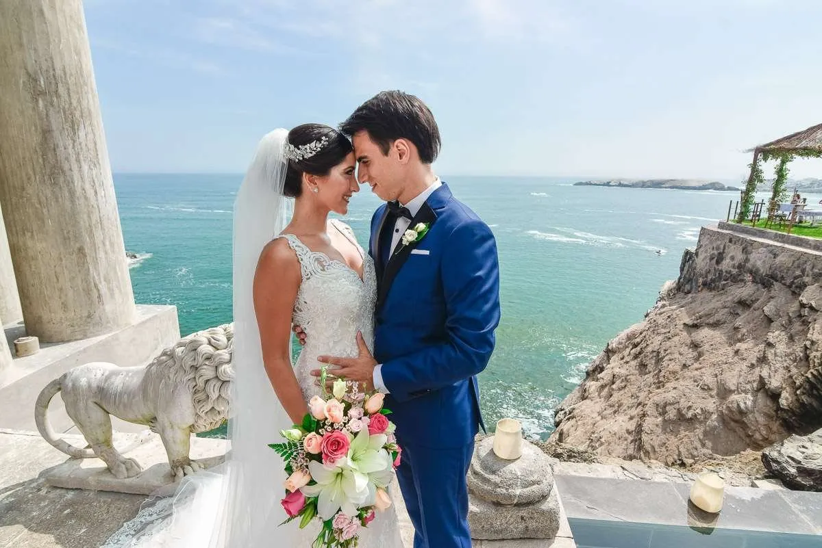 Couple embracing beside a stone balustrade, with open sea behind them