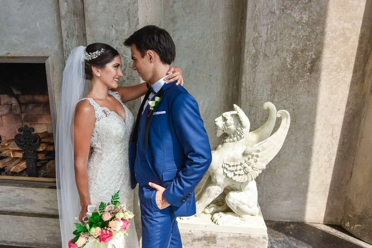 Couple facing the sea, with a winged stone sculpture beside them