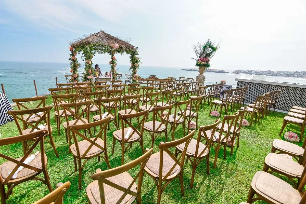 Sillas de madera preparadas para una ceremonia frente al mar