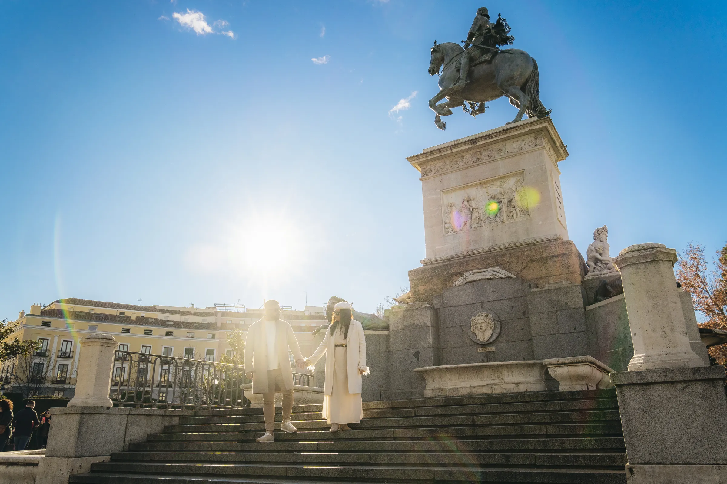Monumento ecuestre ante un edificio histórico, a contraluz