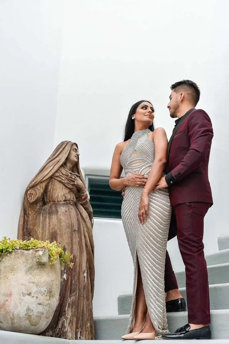 A couple beside a stone sculpture on white steps