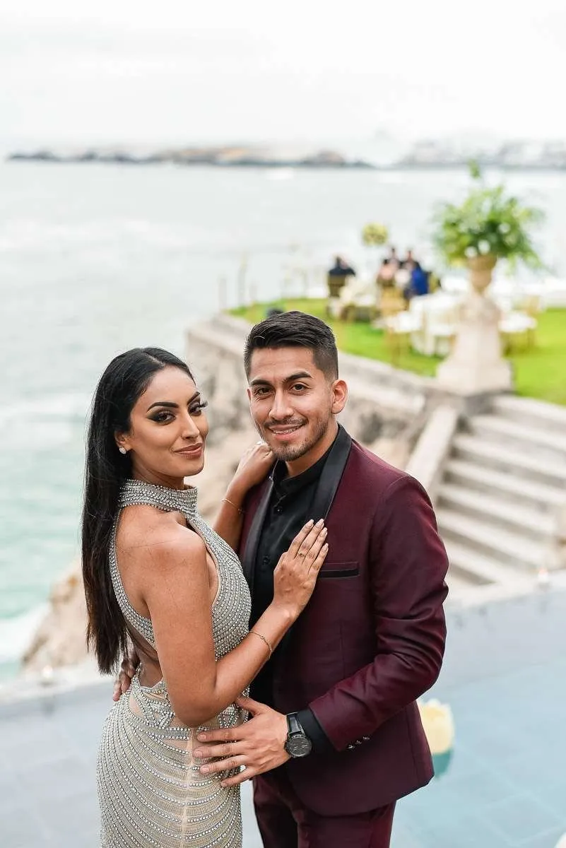Pareja abrazada junto a una terraza con vistas al agua